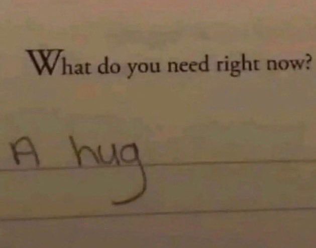 A close-up photo of a printed question 'What do you need right now?' on lined paper, with the handwritten answer 'A hug'…