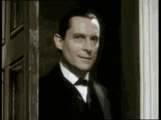 A six-panel sequence from a black-and-white film shows a man in a suit initially looking out a doorway, then pointing, then…