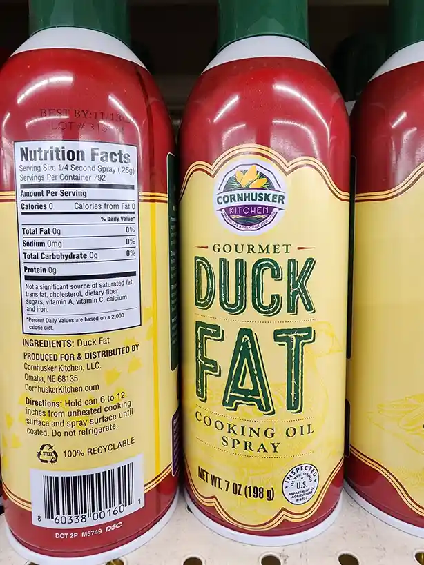 A close-up photo of a red and yellow can of Cornhusker Kitchen Gourmet Duck Fat Cooking Oil Spray, showing its label and…