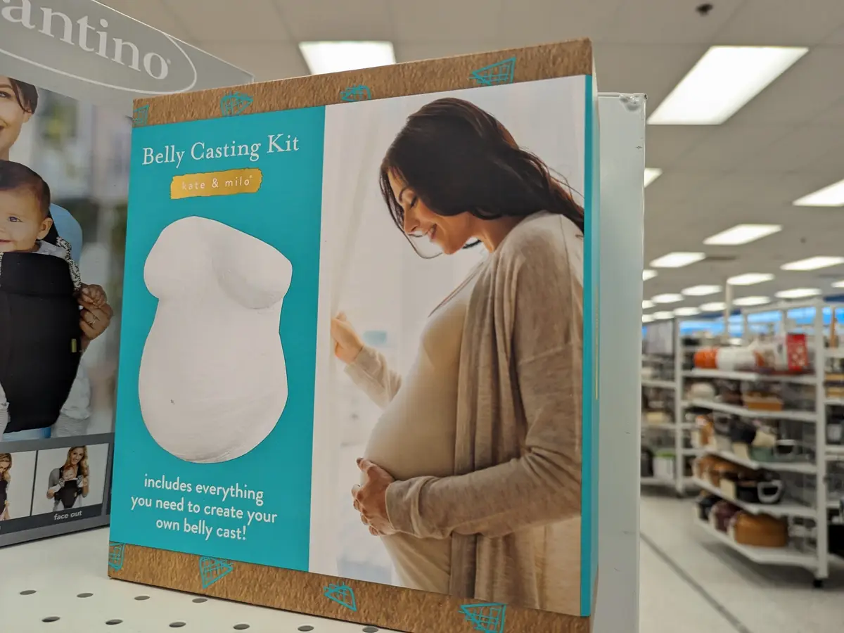 A product box for a 'Belly Casting Kit' by kate & milo is displayed on a store shelf, featuring an image of a smiling…