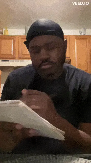 A man in a black t-shirt and black cap is shown in six panels, first writing in a notebook, then looking up with a confused…