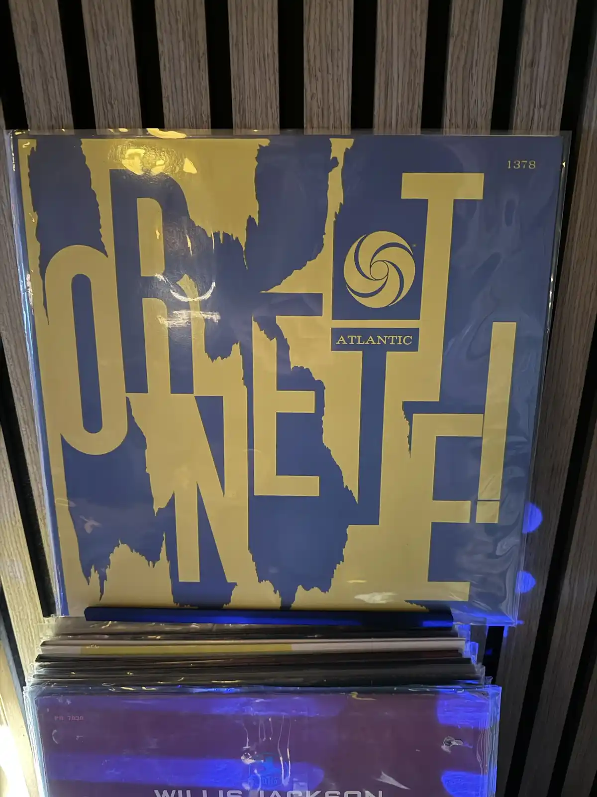 A close-up of a vinyl record album cover with large, gold, dripping letters spelling 'ONE!' on a blue background, featuring…