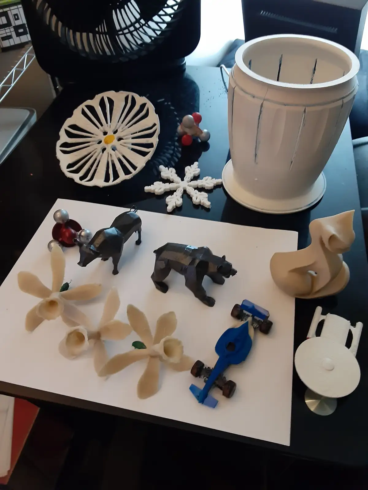 A collection of various 3d printed objects including animal figurines, flowers, a snowflake, a molecular model, and a…