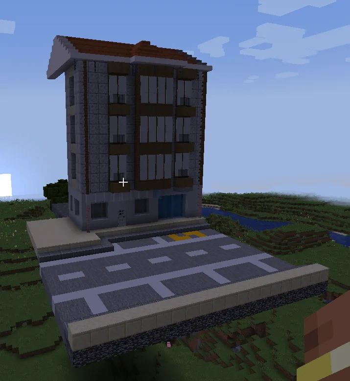 A screenshot from the game Minecraft showing a player's perspective looking at a tall, blocky apartment building with a…