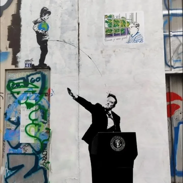 A street art mural depicts a stylized boy holding a globe, seemingly fishing with a line that extends to a man in a suit at…