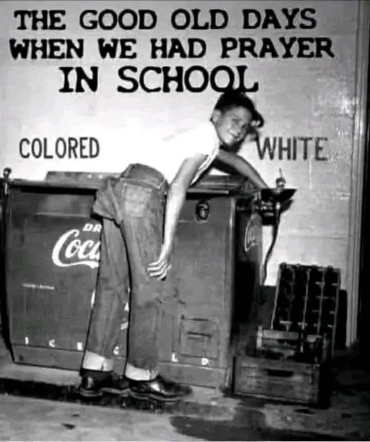 A black-and-white photo shows a young person leaning over a Coca-Cola cooler, with the words 'COLORED' and 'WHITE' painted…