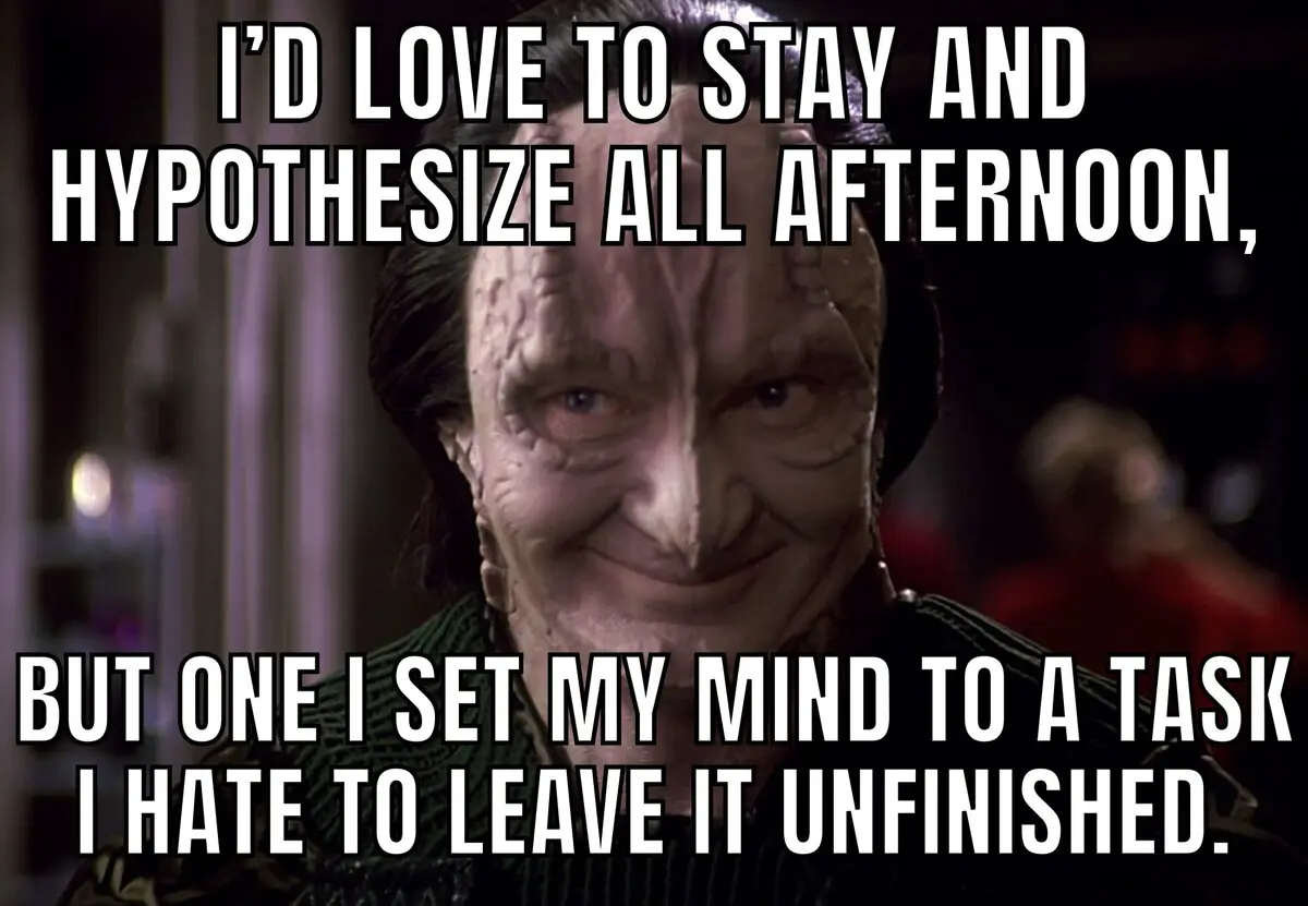 A close-up of a smiling, wrinkled alien character with dark hair and a green uniform, overlaid with white text that reads…
