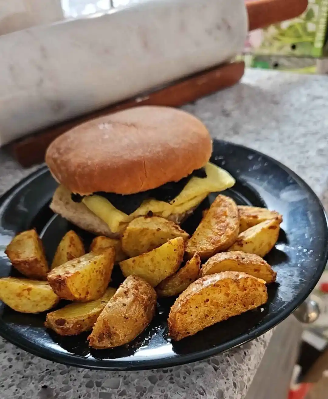 A close-up photo shows a burger on a black plate, featuring a toasted bun, a fried egg, and melted cheese, accompanied by…