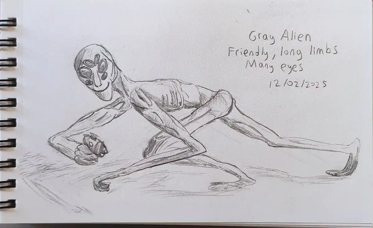 A pencil sketch in a spiral-bound notebook depicts a humanoid alien with a large head, multiple eyes, and long limbs…