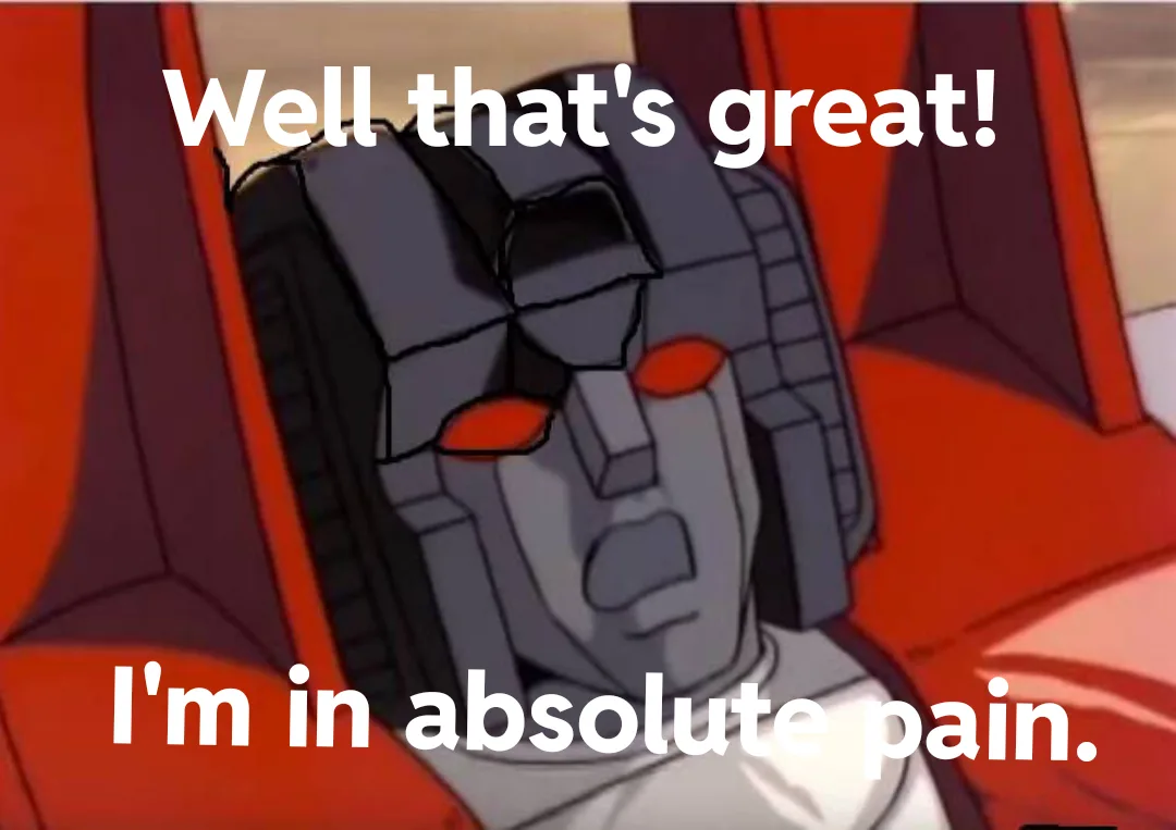 A close-up of a gray, blocky animated robot with red eyes, sitting in a red cockpit. White text overlaid at the top reads…