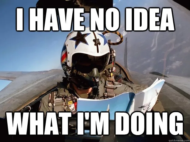 A pilot wearing a white helmet with a star and stripes sits in the cockpit of a fighter jet, holding an open manual or map…