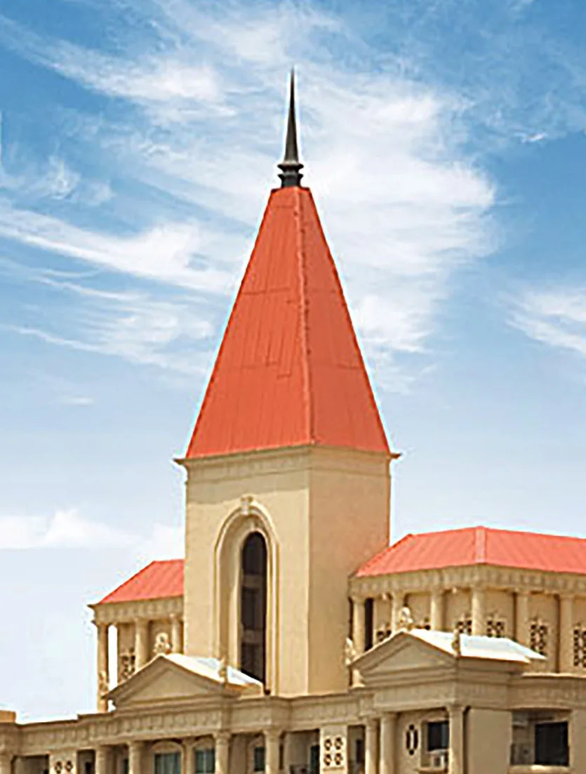A beige building with a prominent red roof and spire under a blue sky with wispy clouds. The overlaid text reads 'i'm not a…