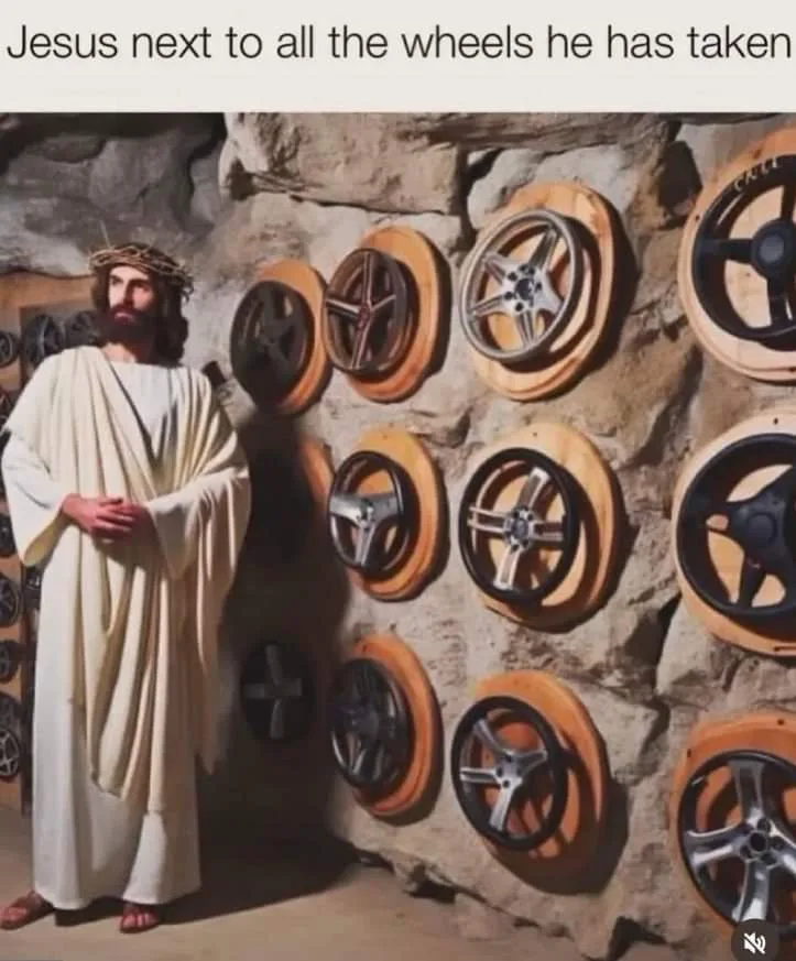 A man dressed as Jesus Christ, wearing a crown of thorns and a white robe, stands beside a stone wall covered with numerous…