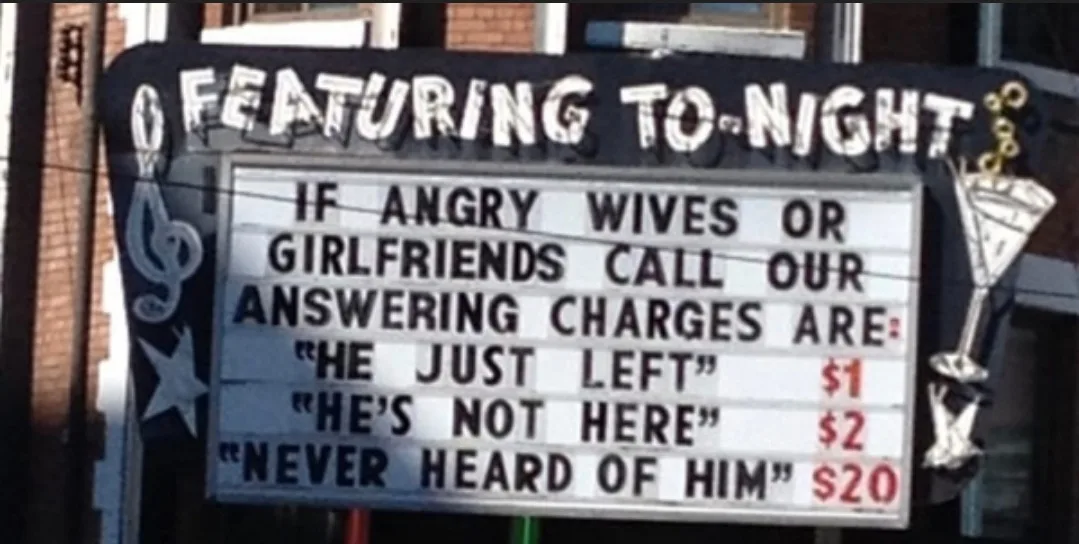 A weathered theater marquee displays a humorous fake service listing for 'answering charges' to angry wives or girlfriends…