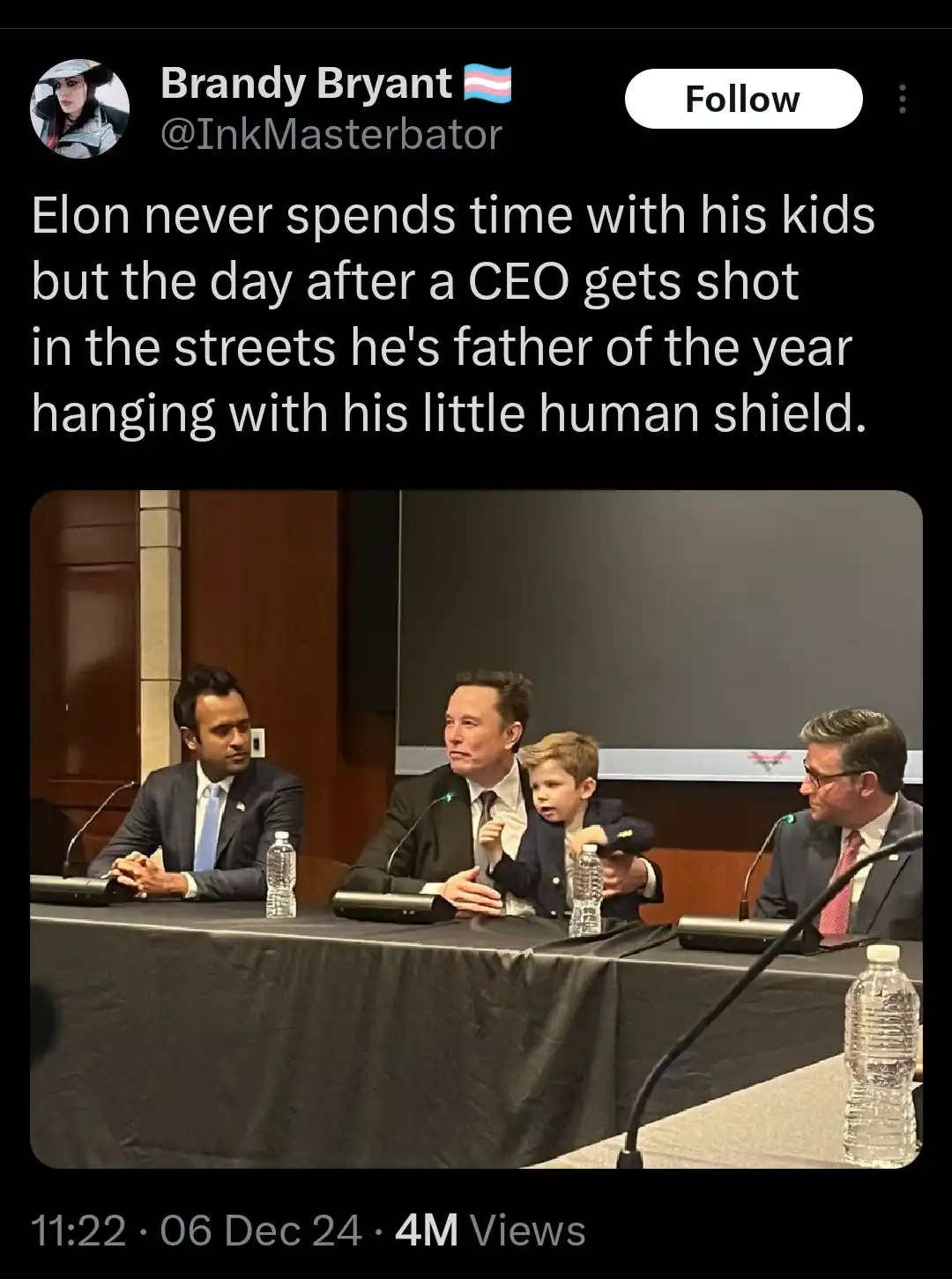 A screenshot of a tweet by Brandy Bryant showing a photo of Elon Musk sitting at a conference table with a young boy on his…