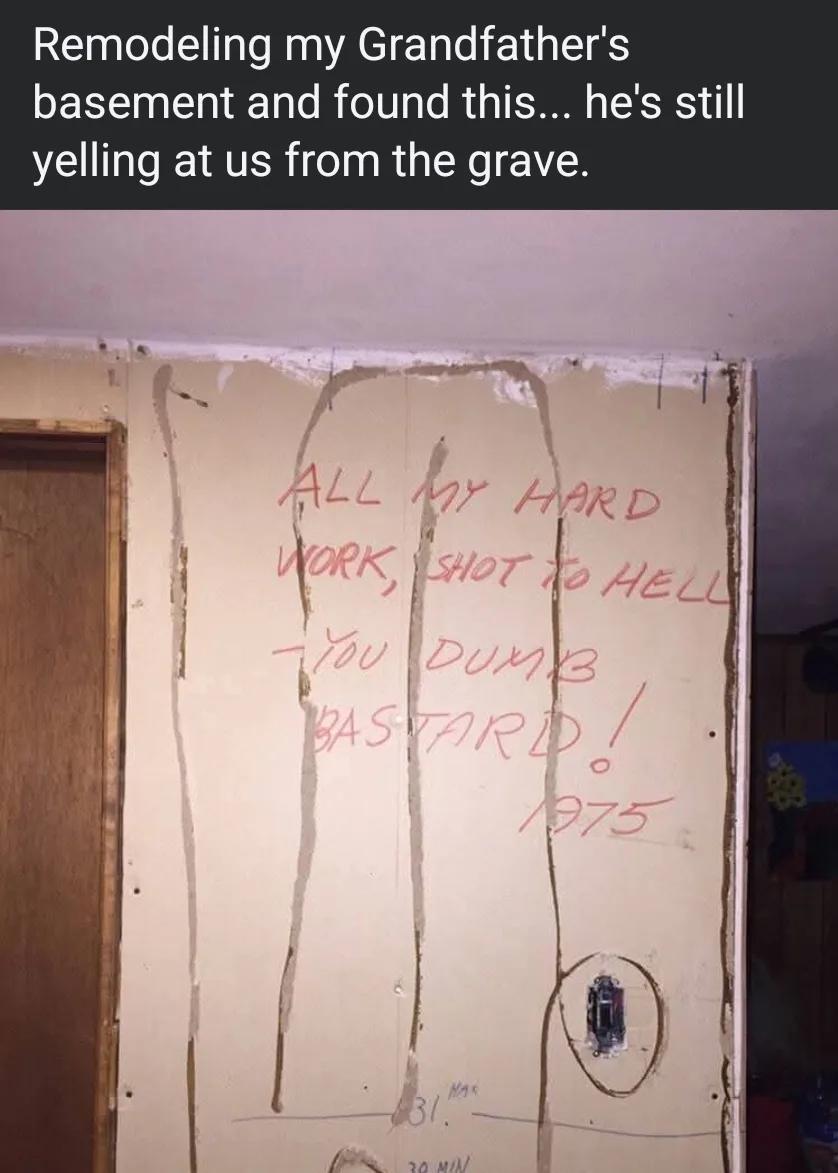 A photo shows a partially stripped drywall wall in a basement with red handwritten text inside a crude outline of a person…