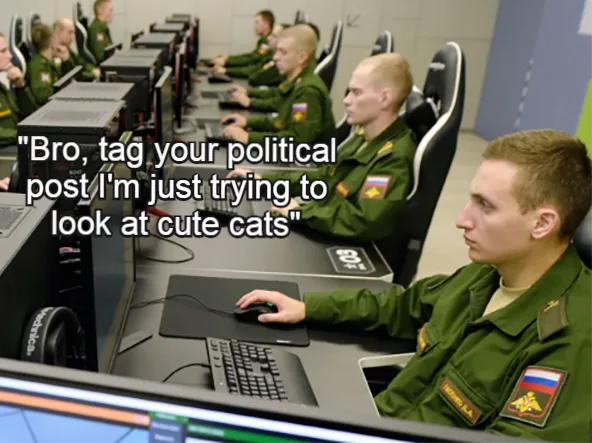 A row of Russian military personnel in green uniforms sit at computer stations in a training facility. The man in the…