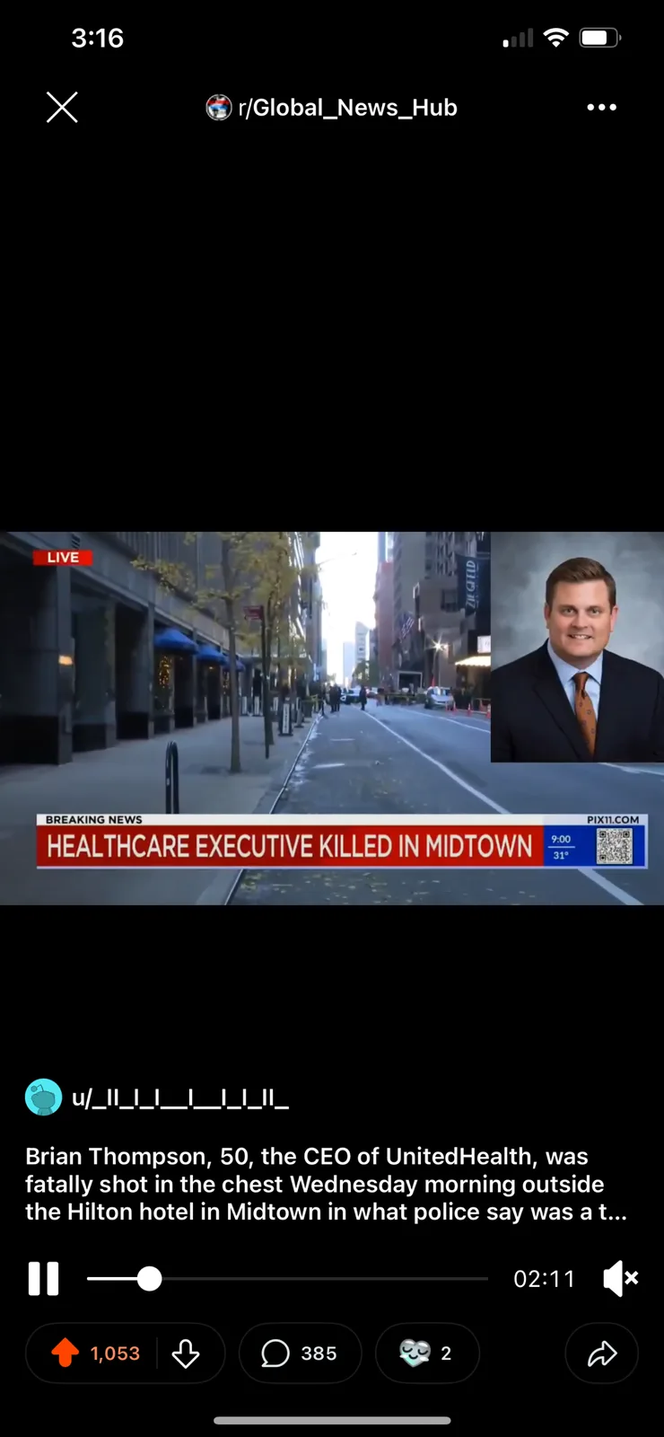 A news broadcast shows a live street scene in a city with police tape and people in the distance, while a smiling man in a…