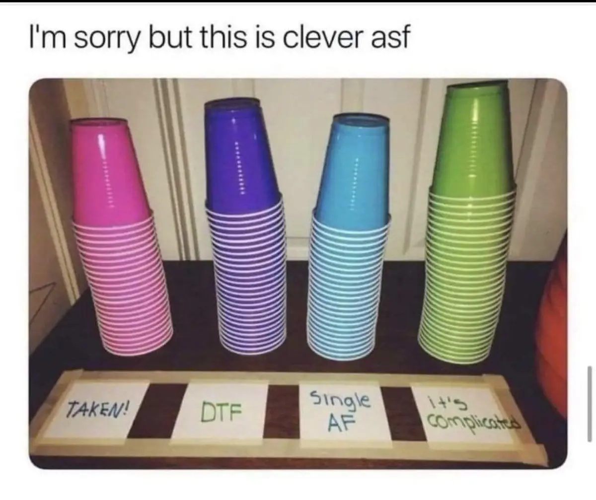 Four stacks of colorful plastic cups (pink, purple, blue, green) are arranged on a table, each labeled with a sticky note…