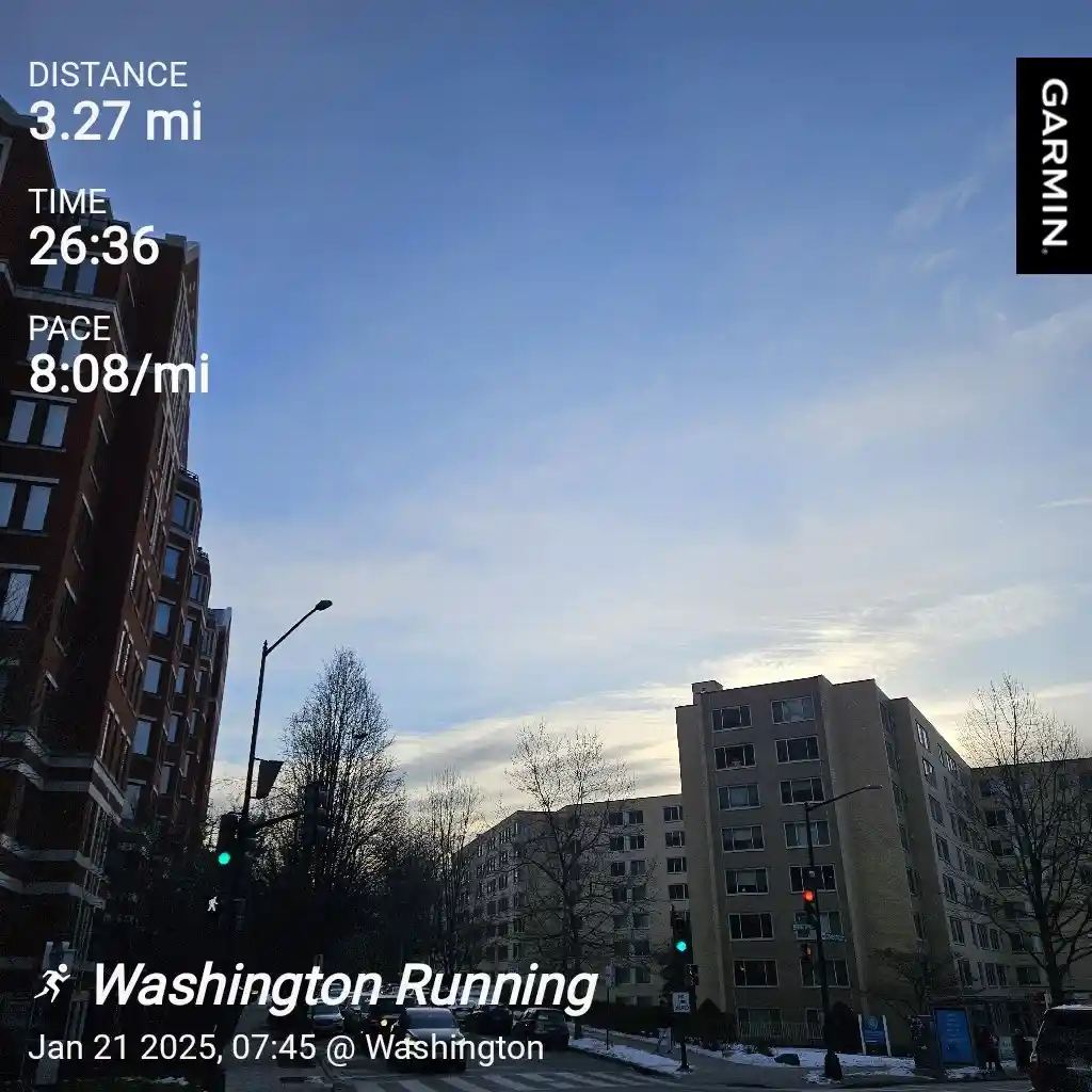 A Garmin fitness tracker screenshot overlaid on a city street photo showing a 3.27-mile run completed in 26 minutes and 36…