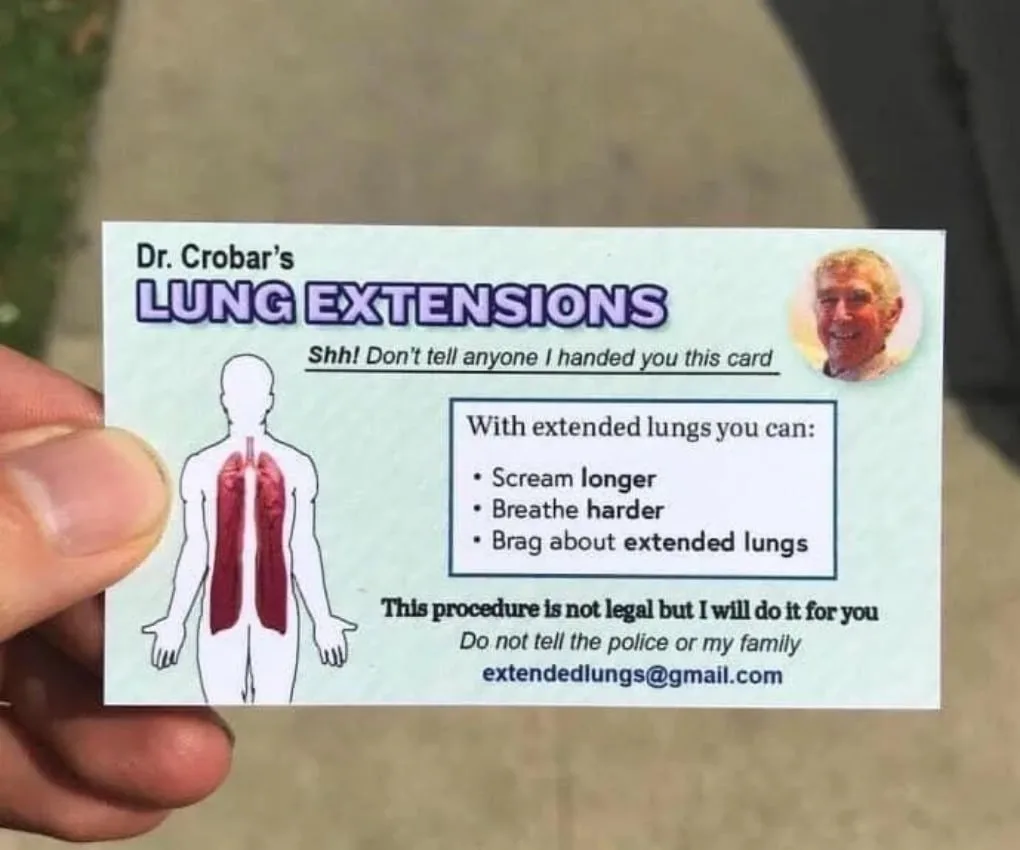 A hand holds a light green business card for 'Dr. Crobar's LUNG EXTENSIONS' featuring a human silhouette with red lungs, a…