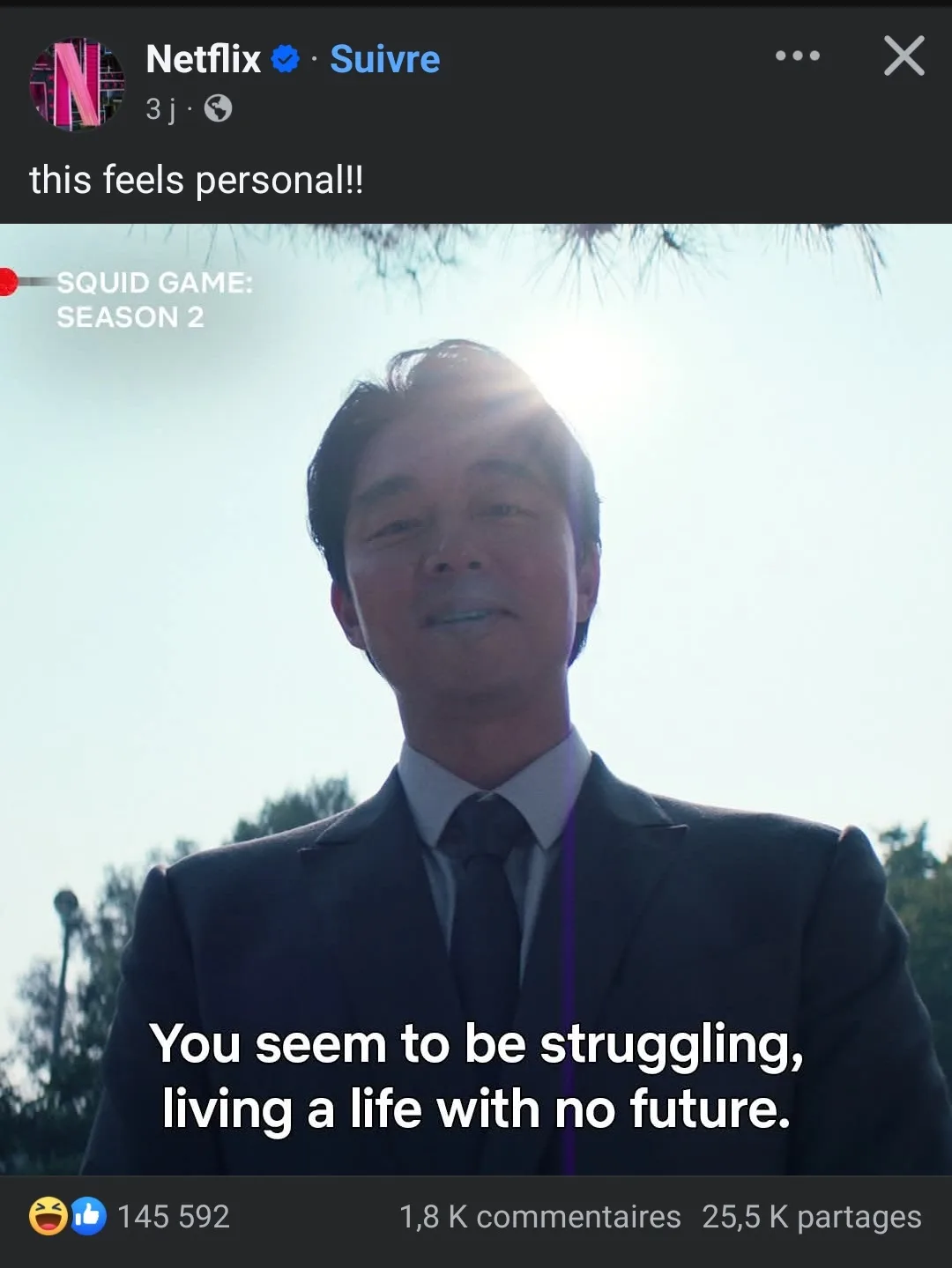 A screenshot from Netflix's 'Squid Game: Season 2' shows a man in a suit smiling at the camera with the sun behind him…