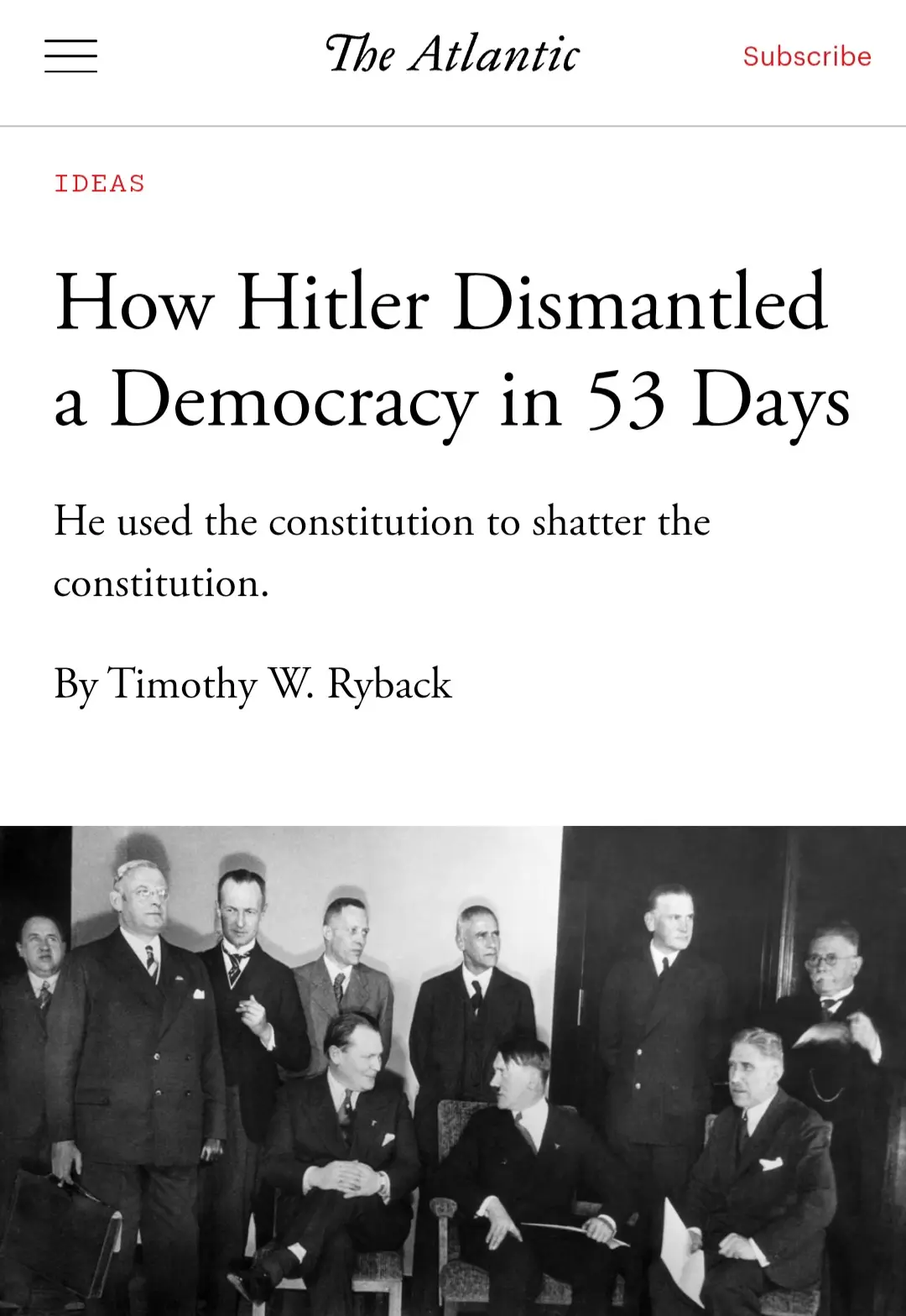 A black-and-white historical photo shows Adolf Hitler seated among other men in suits, with a The Atlantic magazine article…