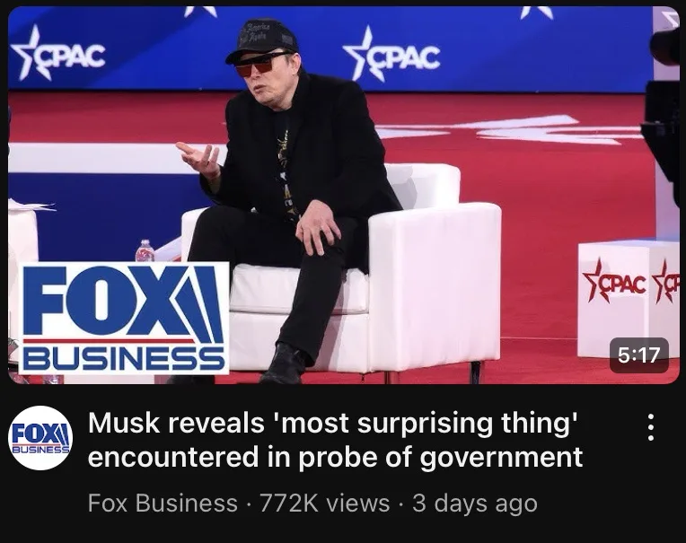 A man wearing a black cap and sunglasses sits in a white chair on a red carpet stage with 'CPAC' logos in the background. A…