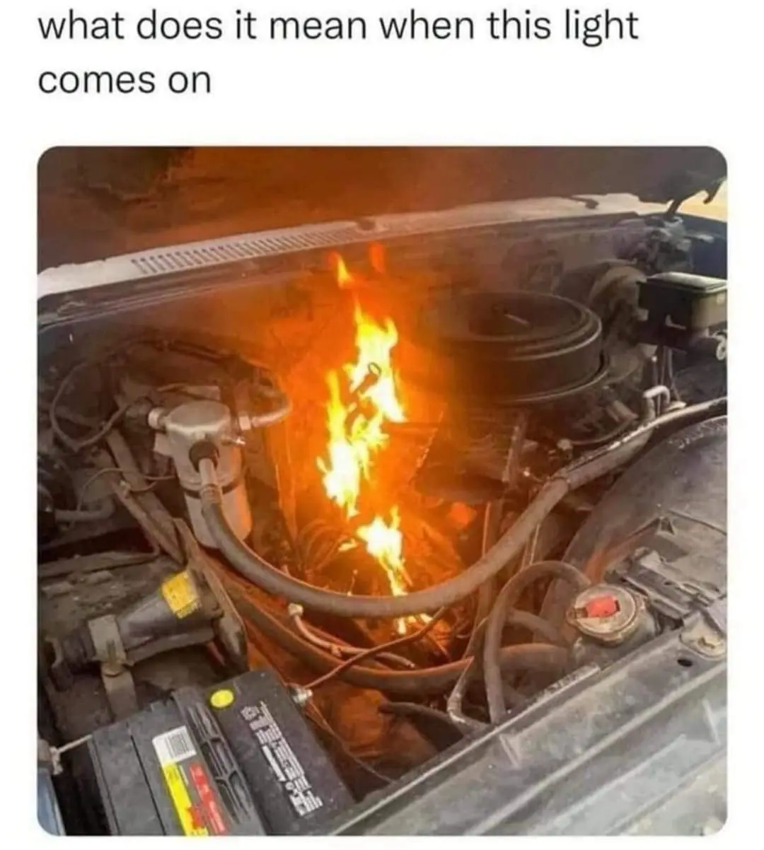 An engine bay is engulfed in bright orange flames, with visible hoses, wires, and a battery. The overlaid text asks, 'what…