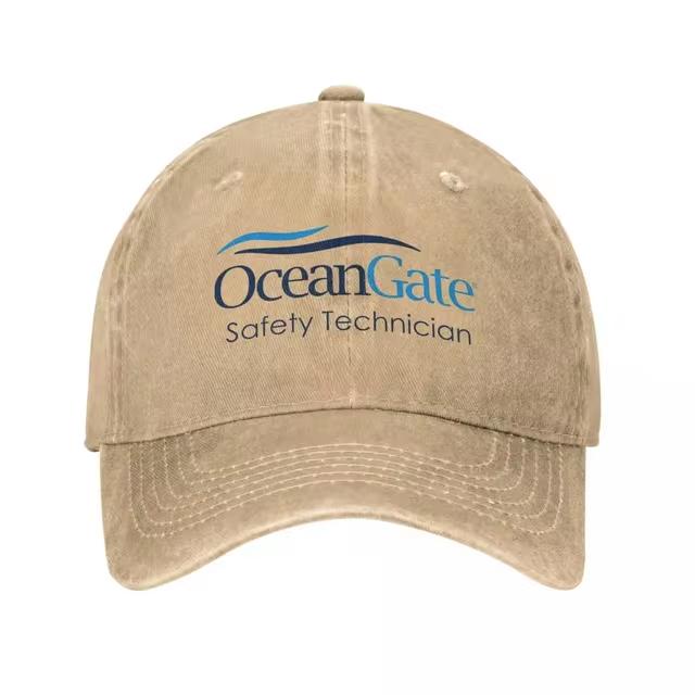 A beige, distressed baseball cap with a logo that reads 'OceanGate Safety Technician' in blue and black text, featuring a…