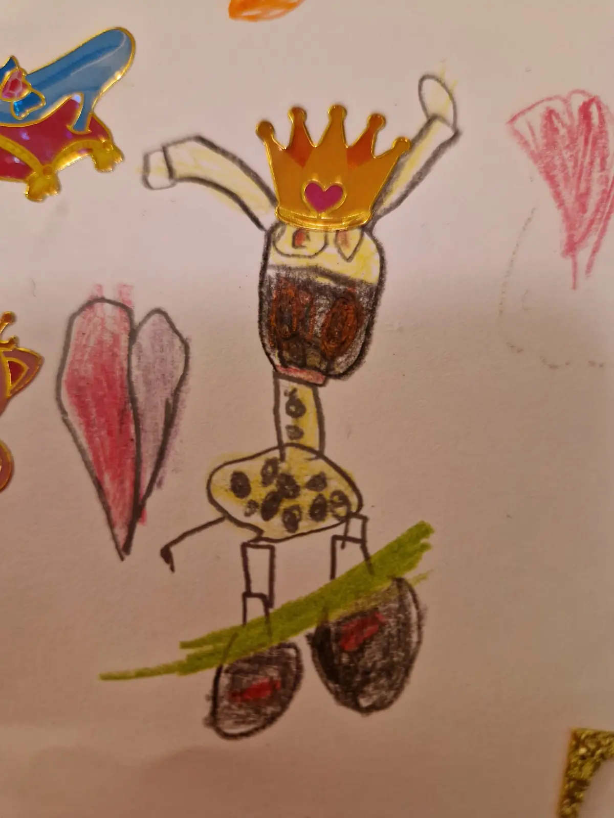 A child's crayon drawing of a tall, spotted figure wearing a gold crown with a pink heart, standing on a green line with…