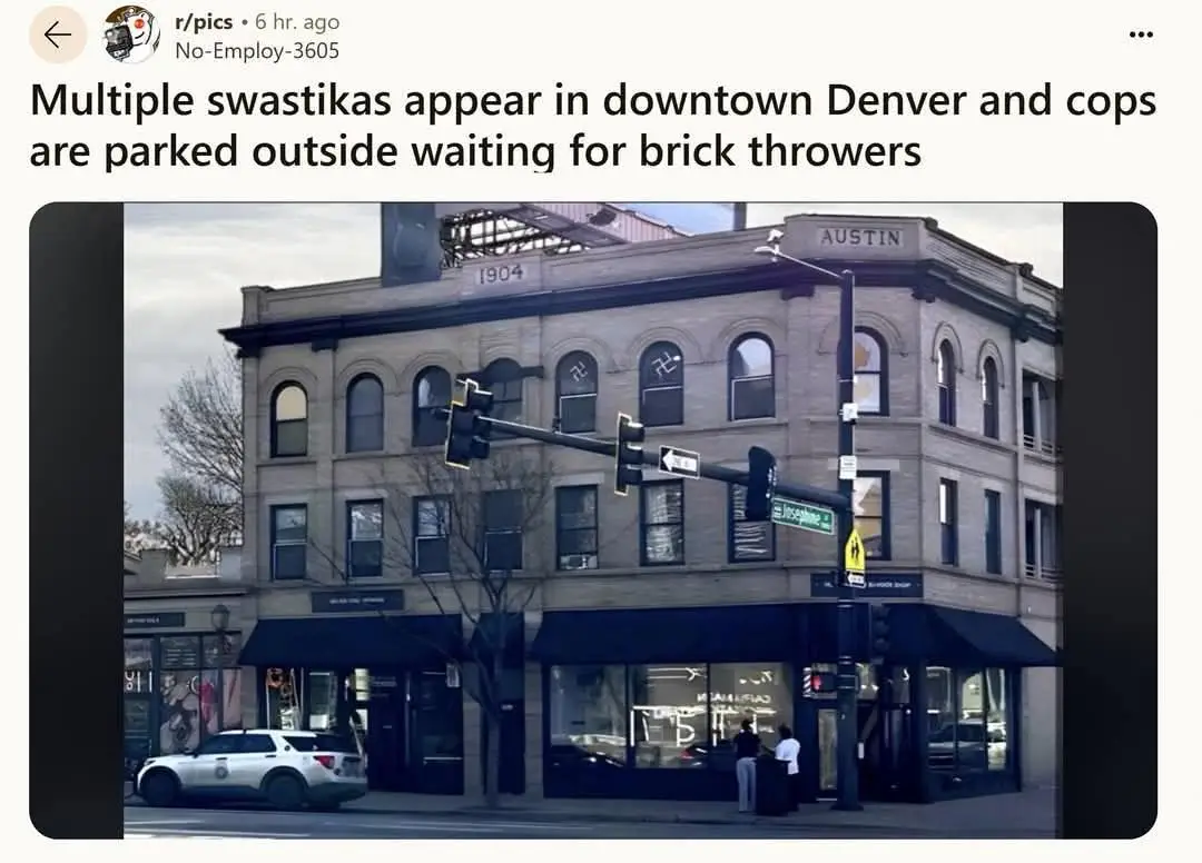 A street-level photo shows a corner building in downtown Denver with multiple swastikas visibly spray-painted on several…