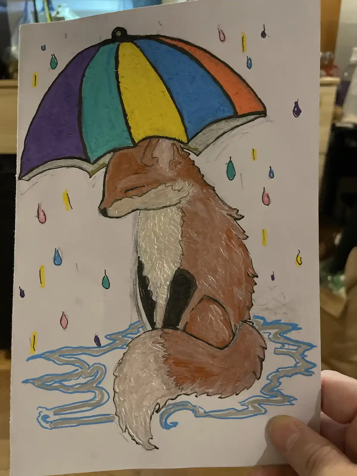 A hand-drawn illustration shows a fox sitting in water under a colorful striped umbrella as raindrops fall around it. The…