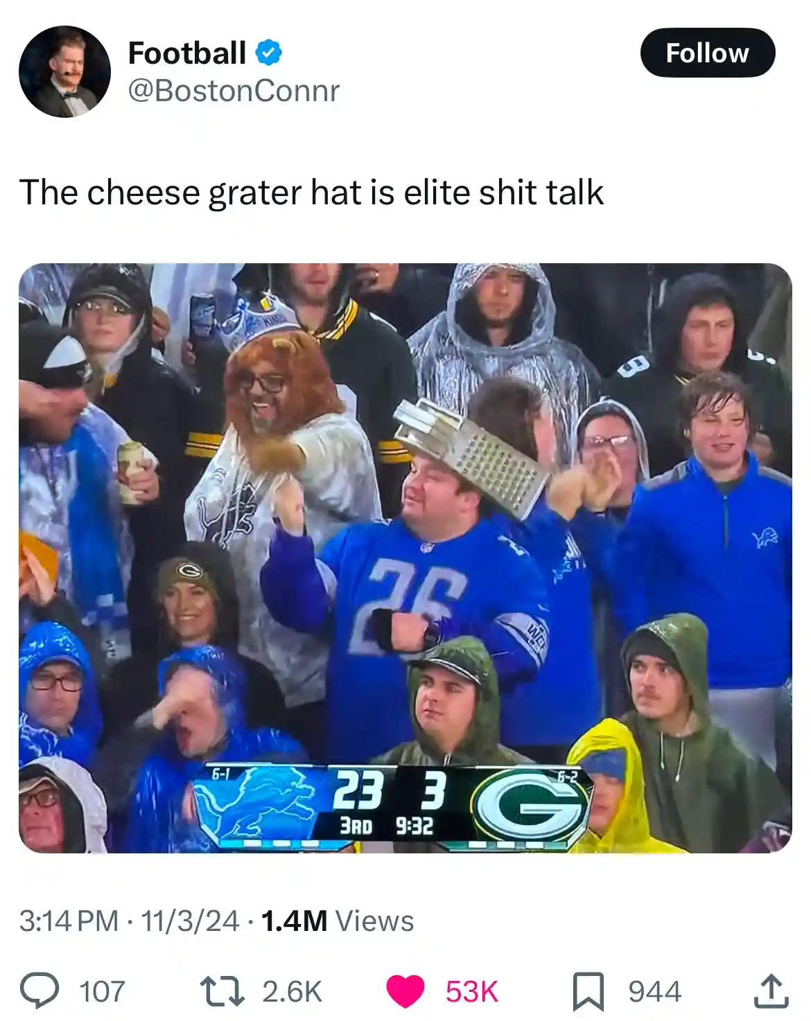 A photo of football fans at a game, one man in a blue jersey has a metal cheese grater on his head while cheering. The…