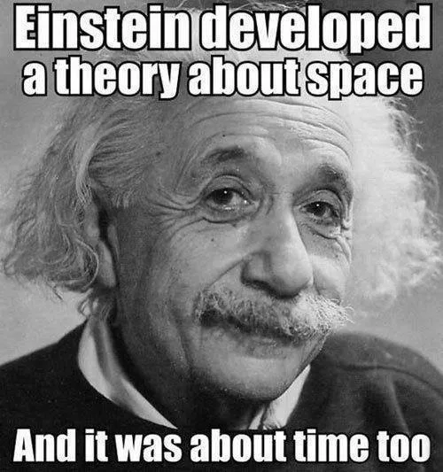 A black-and-white photo of Albert Einstein with his characteristic wild hair and mustache, looking slightly amused. White…