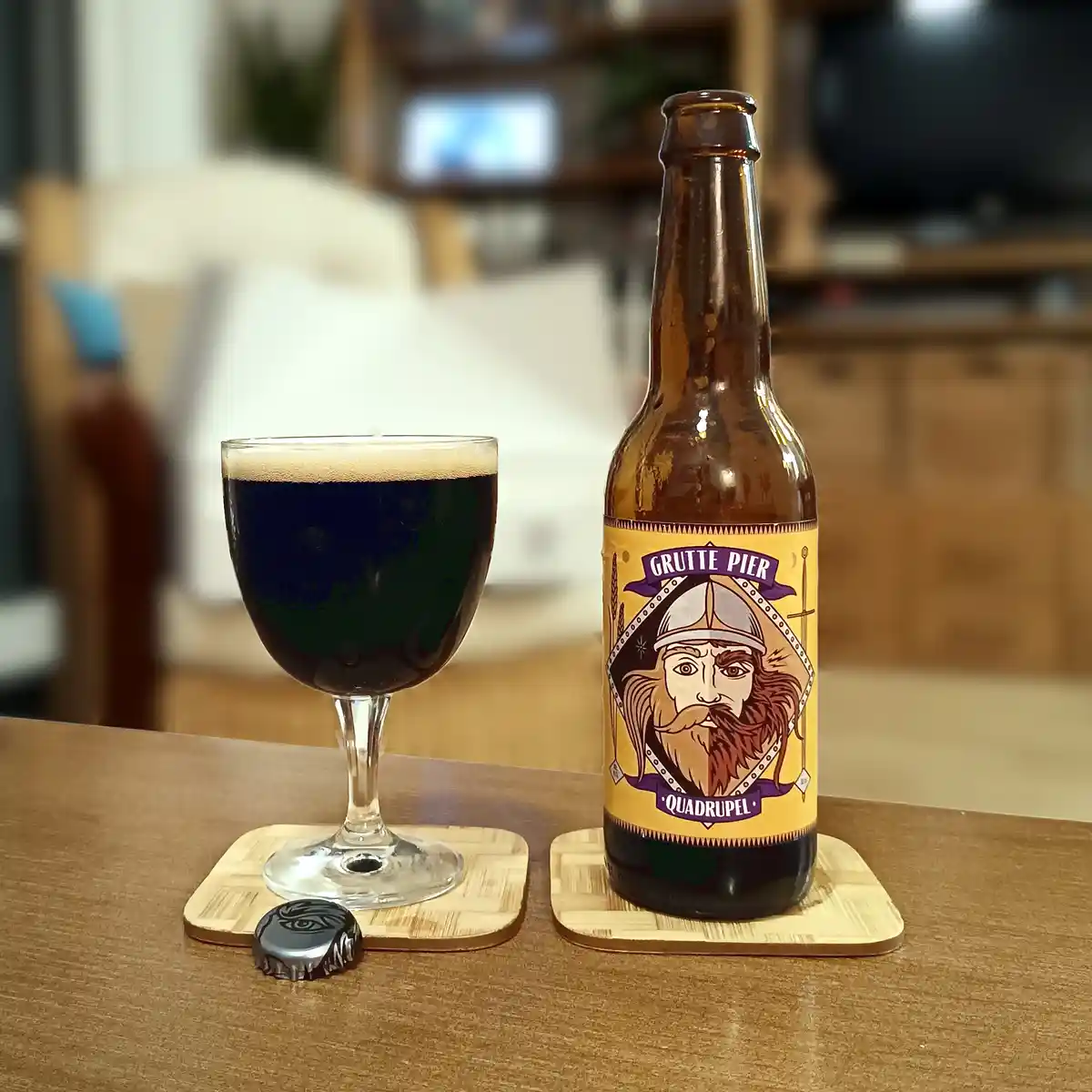 A bottle of Grutte Pier Quadrupel beer with a label featuring a bearded Viking-like figure sits next to a glass filled with…