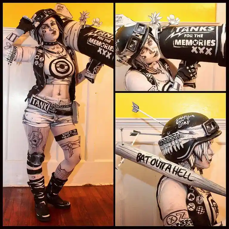 A person in a punk-inspired costume with tattoos, a helmet, and a belt labeled 'TANK' poses with a large black prop tank…