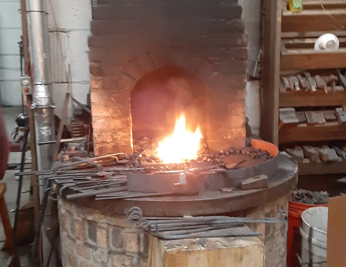 A fiery blacksmith forge with glowing embers and tools around it, overlaid with the text 'i'm not lazy, i'm just conserving…