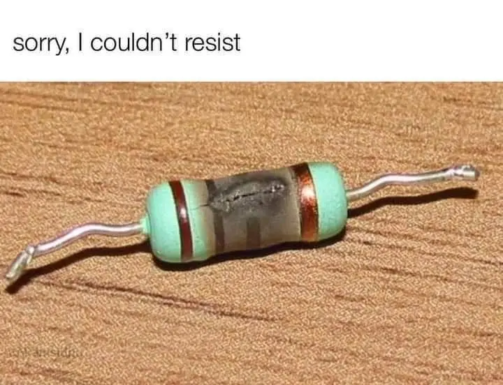 A close-up photo of a physical resistor electronic component, visibly broken in half with its metal leads bent outward…