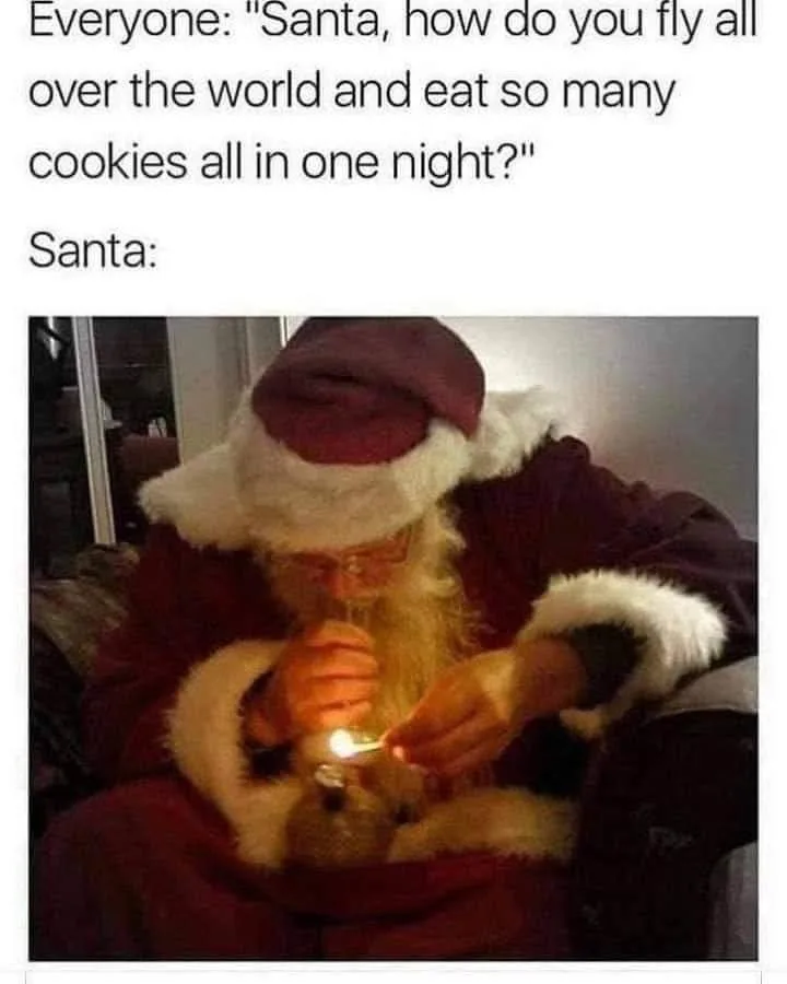 A person dressed as Santa Claus, wearing a red suit with white fur trim and a matching hat, is seated and lighting a match…