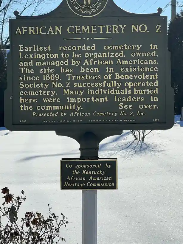 A historical marker for African Cemetery No. 2 in Lexington, Kentucky, stands in a snowy landscape. The plaque details its…