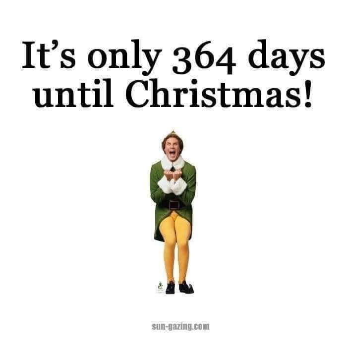 A man in a green elf costume with yellow tights and a white collar stands with his mouth open in an excited yell, hands…