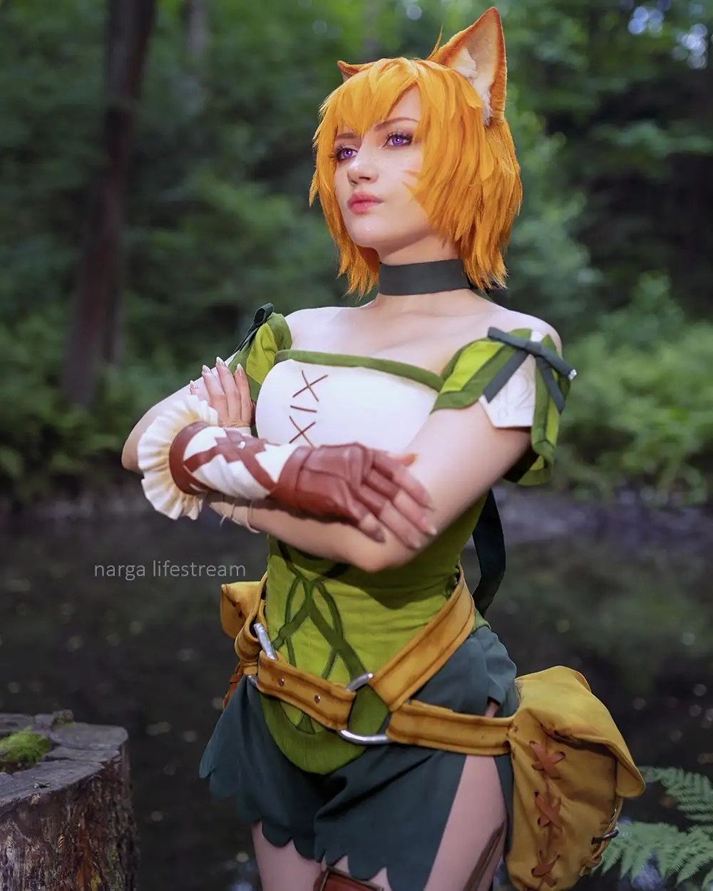 A person in a detailed cosplay of a fox-like character with orange hair, pointed ears, and a green and white outfit stands…