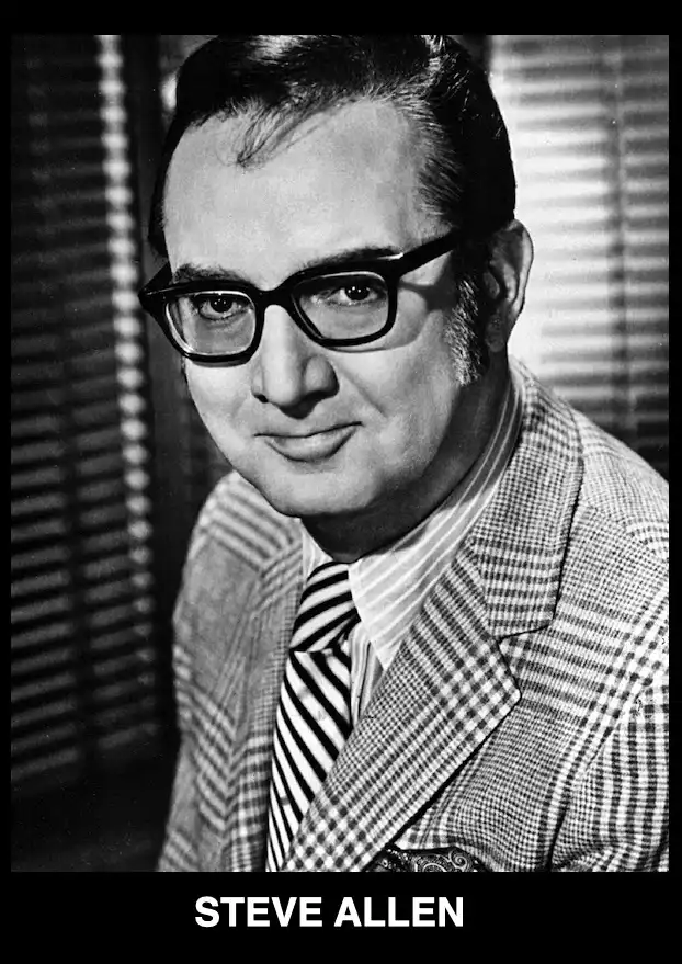 A black and white portrait of Steve Allen, a man with dark-rimmed glasses, a checkered suit jacket, and a striped tie…