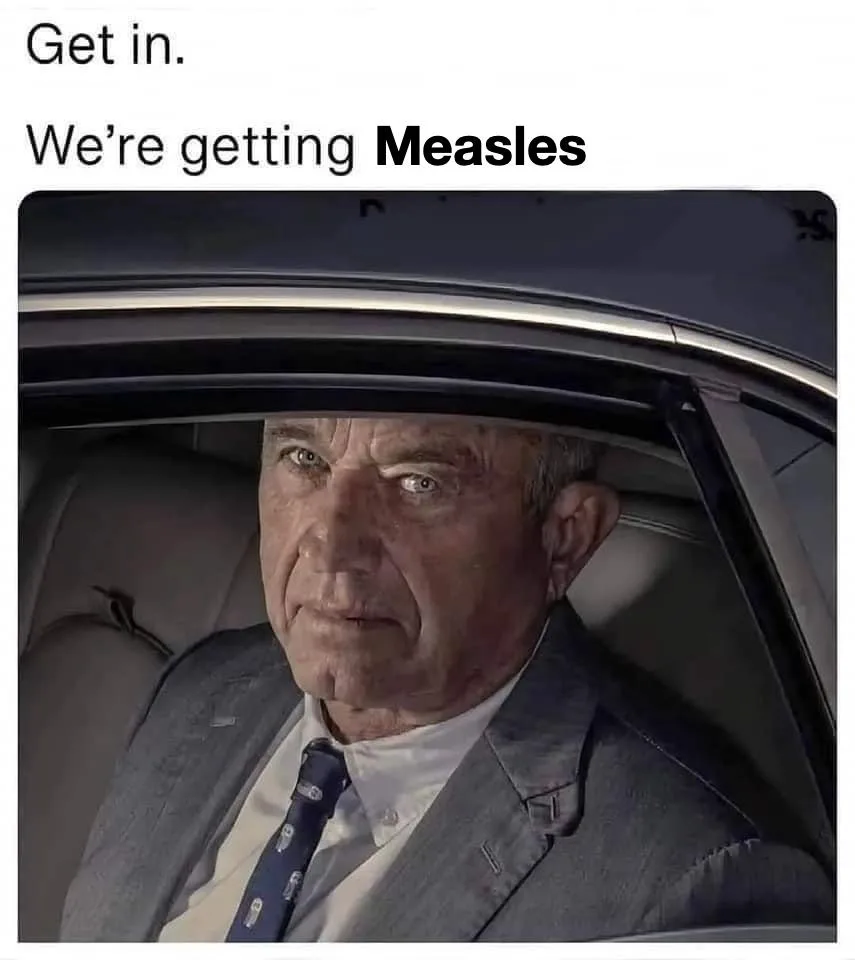 A man in a suit and tie sits in the driver's seat of a car, looking intensely at the viewer. The overlaid text reads 'Get…