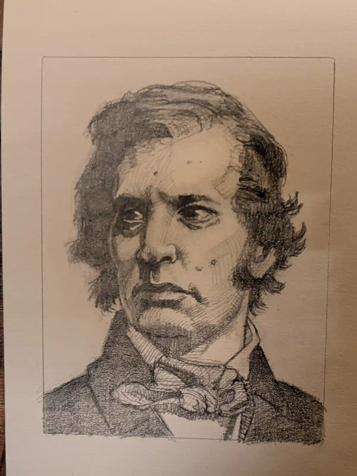 A pencil sketch of a man with dark, wavy hair, a serious expression, and a bow tie, drawn on textured paper with a light…