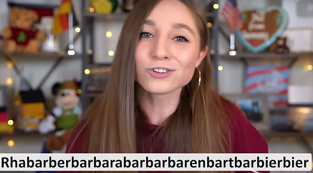A woman with long brown hair and a red shirt smiles at the camera while a text overlay at the bottom reads…