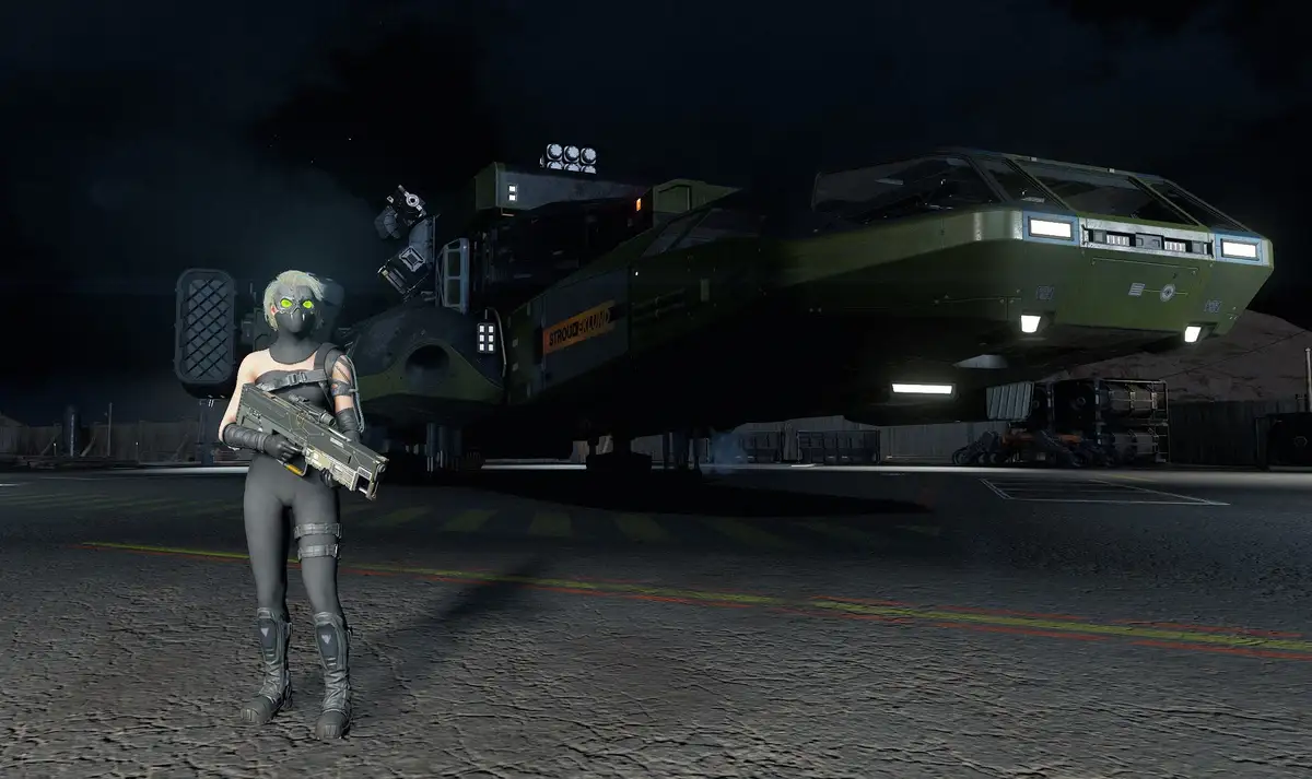 A female character in futuristic combat gear with glowing green eyes stands in front of a large, green military hovercraft…
