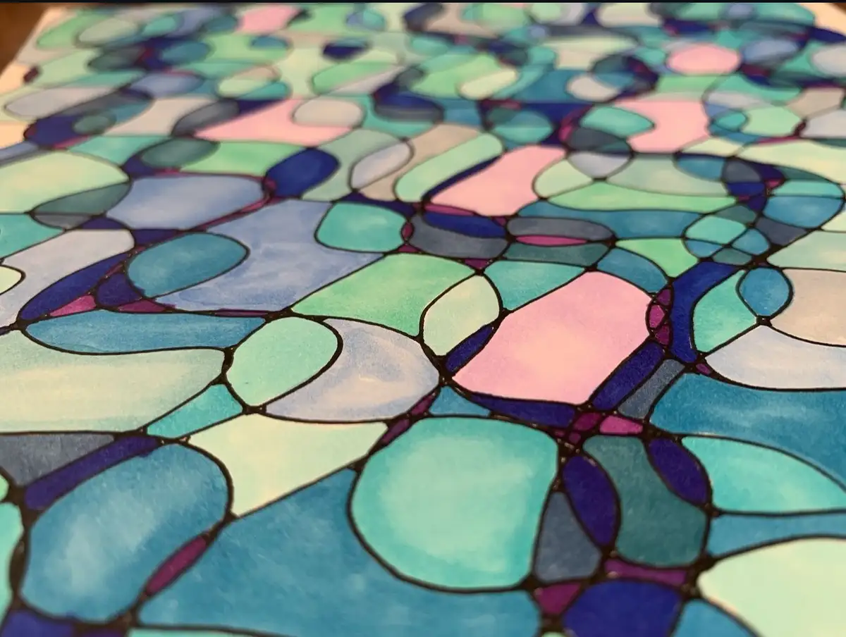 A close-up photo of a colorful, abstract artwork resembling stained glass with irregular, rounded shapes in shades of blue…