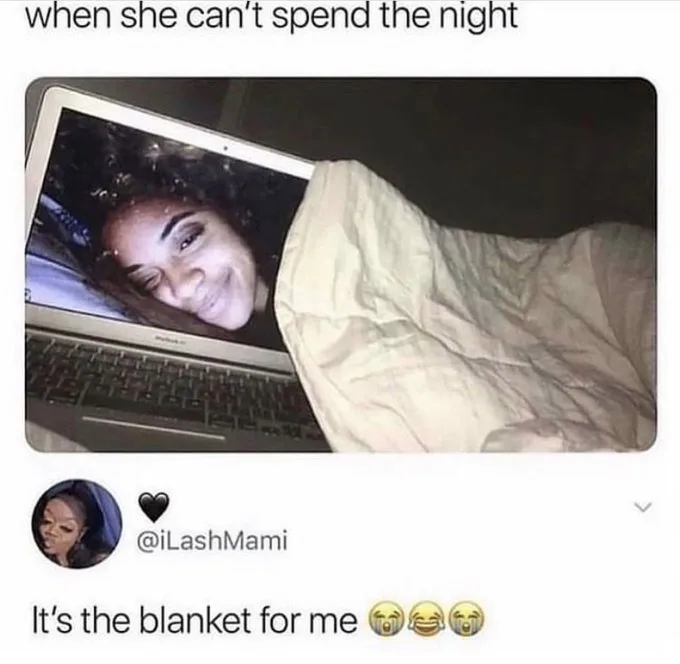 A person is tucked under a beige blanket, with only their face visible on the laptop screen, smiling. The overlaid text…